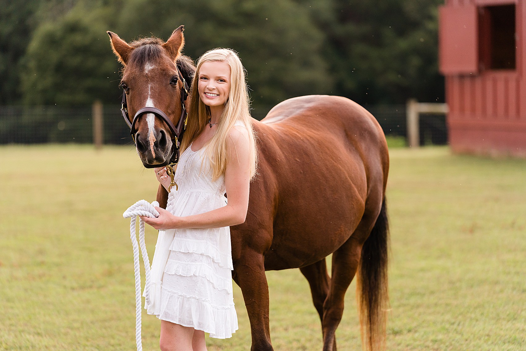 senior photos with horse on farm barn
