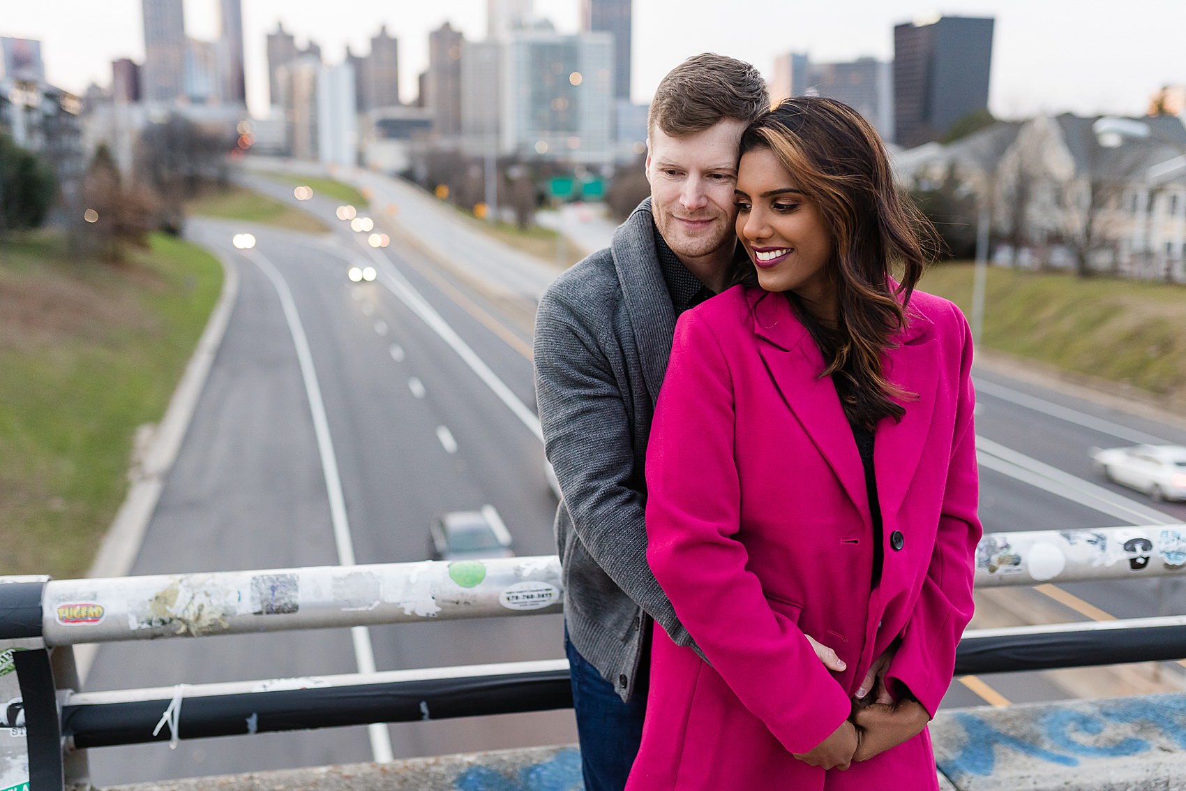 engaged couple pink coat on bridge