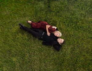 couple laying in a field of grass
