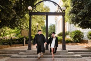 couple walks through arch graduation