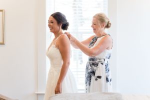 mother zipping brides dress